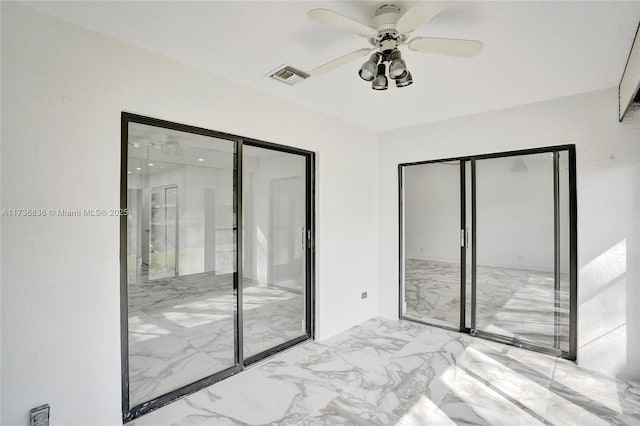 unfurnished bedroom with marble finish floor, visible vents, and ceiling fan