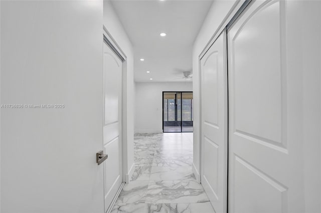 corridor featuring marble finish floor, baseboards, and recessed lighting