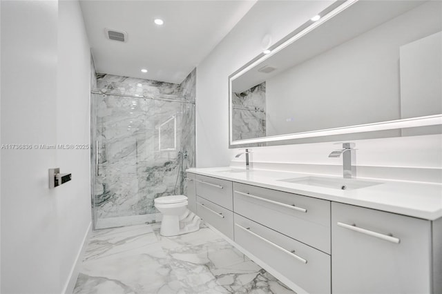 bathroom featuring toilet, a sink, marble finish floor, a marble finish shower, and double vanity