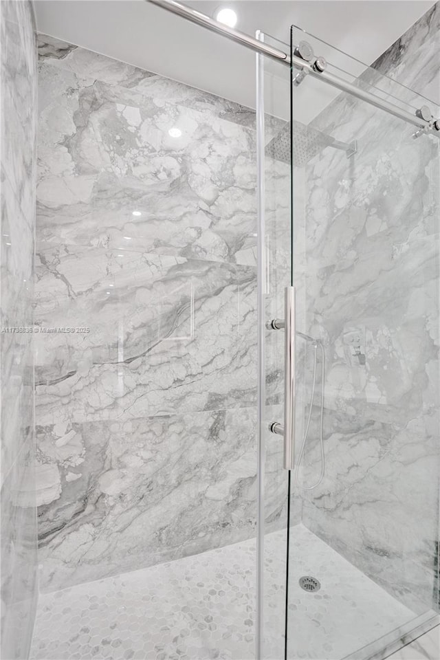 bathroom with a marble finish shower