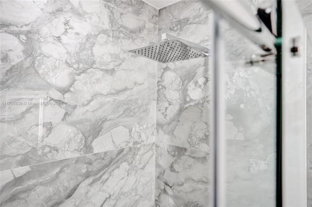 interior details featuring a tile shower