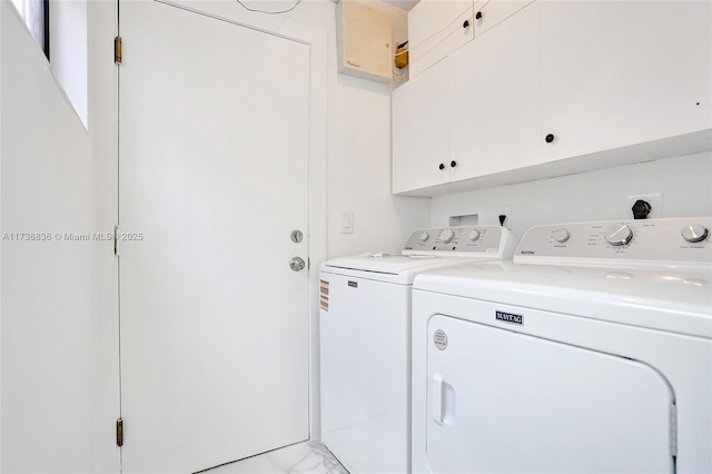 washroom with marble finish floor, washing machine and clothes dryer, and cabinet space