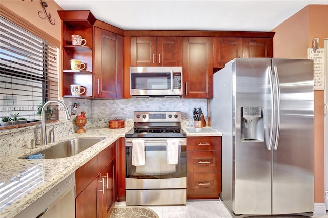 kitchen with appliances with stainless steel finishes, sink, backsplash, and light stone counters