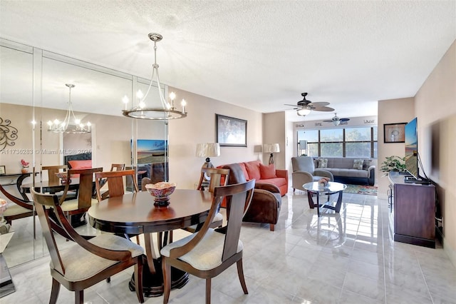 dining area featuring ceiling fan with notable chandelier and a textured ceiling