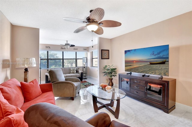 living room featuring ceiling fan and a textured ceiling