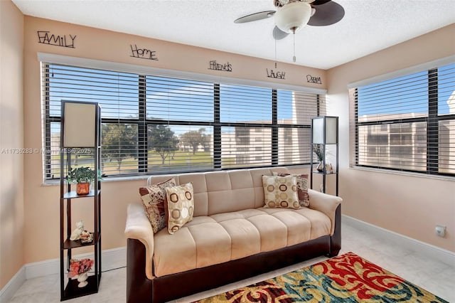 living room with ceiling fan and a textured ceiling