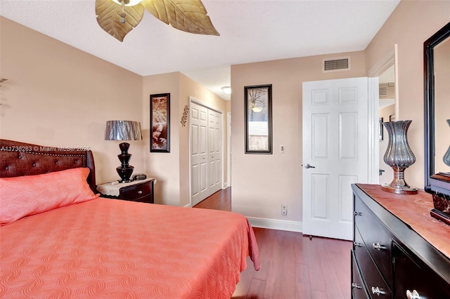 bedroom with dark hardwood / wood-style floors, ceiling fan, and a closet