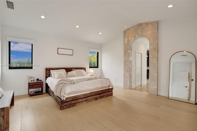 bedroom with vaulted ceiling and light hardwood / wood-style floors