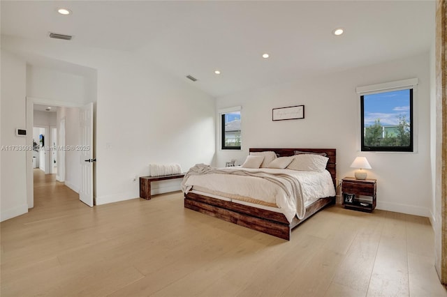 bedroom with lofted ceiling and light hardwood / wood-style flooring