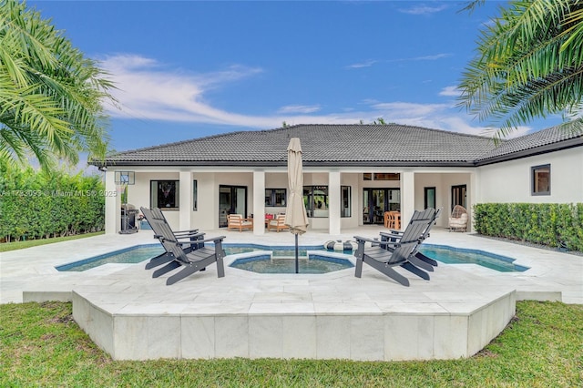 view of swimming pool with an in ground hot tub and a patio