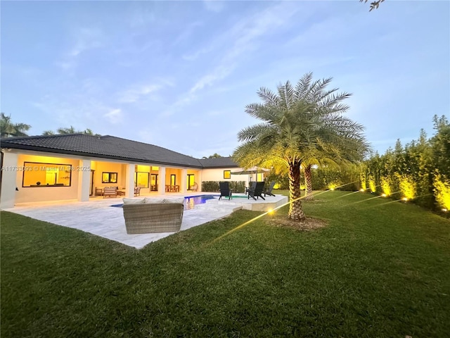 rear view of property with a patio and a lawn