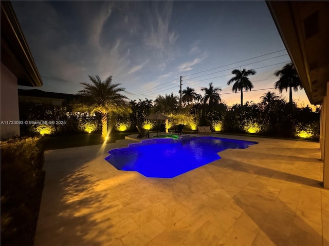 pool at dusk with a patio