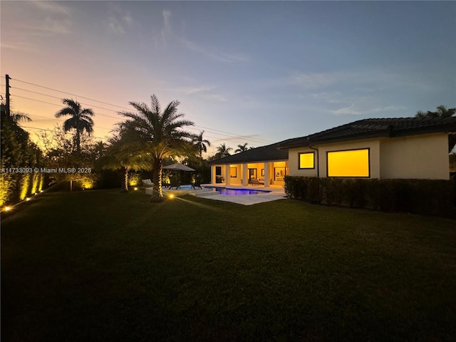 yard at dusk with a patio area