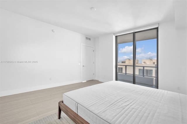 bedroom featuring expansive windows and access to exterior