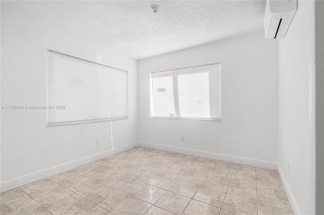 unfurnished room featuring a wall mounted air conditioner and a textured ceiling