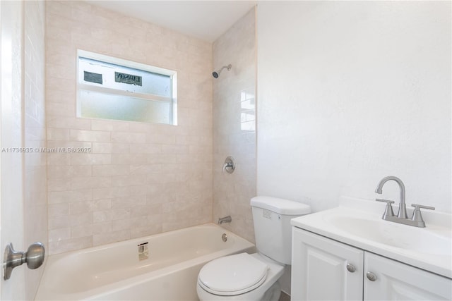 full bathroom featuring vanity, tiled shower / bath, and toilet