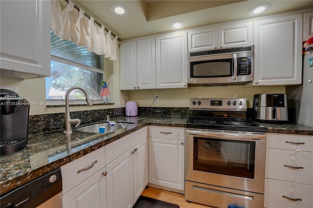 kitchen featuring appliances with stainless steel finishes, sink, and white cabinets