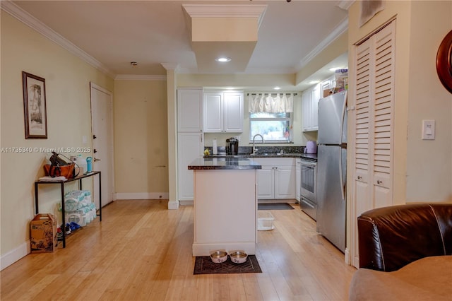 kitchen featuring sink, crown molding, light hardwood / wood-style flooring, white cabinetry, and stainless steel appliances