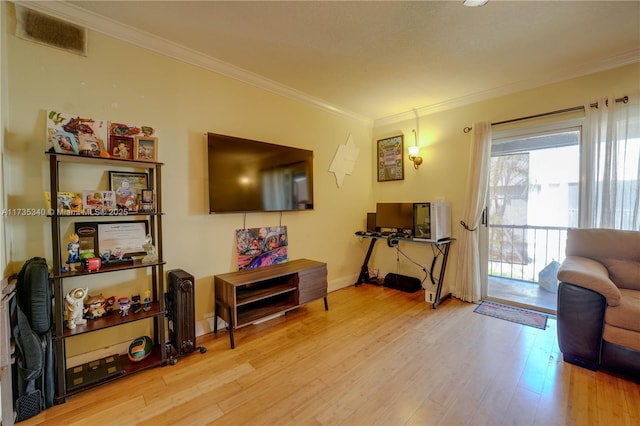 sitting room with ornamental molding and light hardwood / wood-style floors