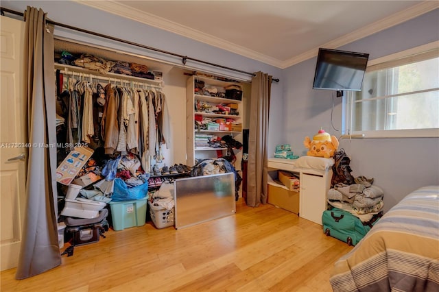 bedroom with crown molding, a closet, and light wood-type flooring