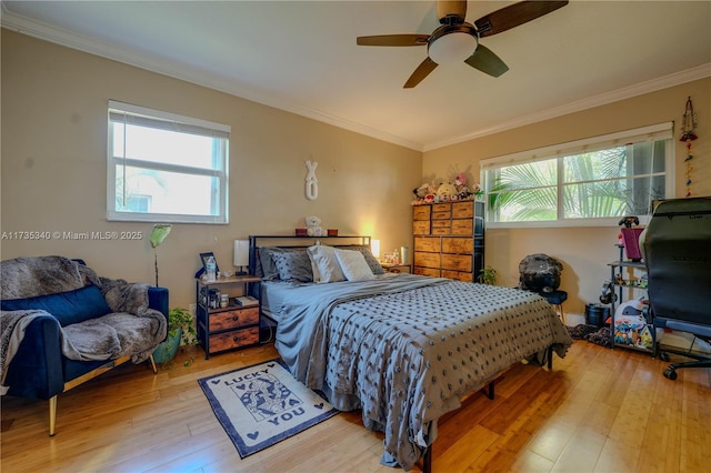 bedroom with ornamental molding, ceiling fan, and light hardwood / wood-style floors