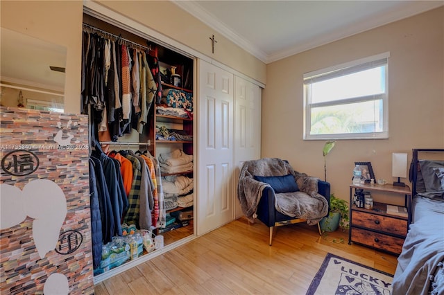 bedroom featuring multiple closets, ornamental molding, and light hardwood / wood-style flooring