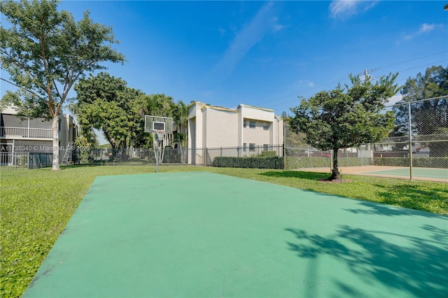 view of sport court with a yard