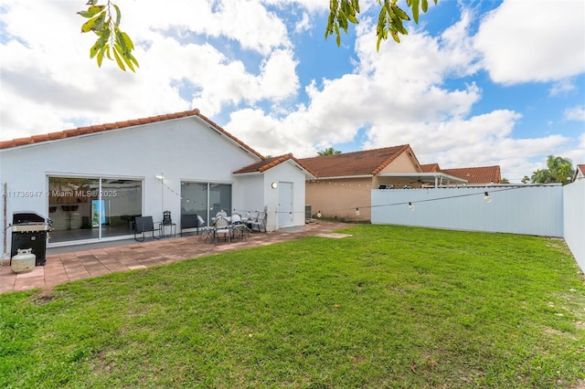 back of house featuring a patio area and a lawn