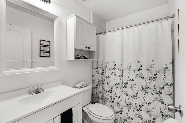 bathroom featuring vanity, a shower with shower curtain, and toilet