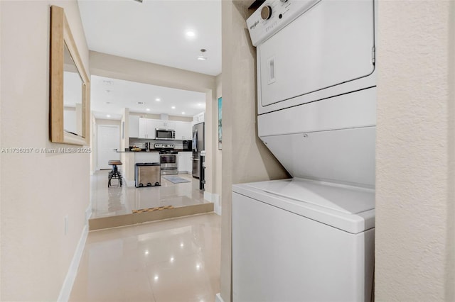 laundry room featuring tile patterned flooring and stacked washer / drying machine