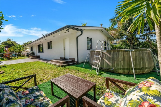 rear view of house featuring a yard and a patio