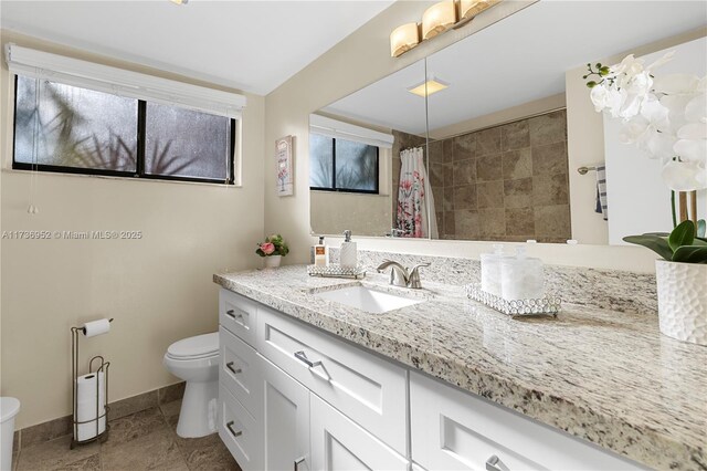 bathroom with vanity, curtained shower, and toilet