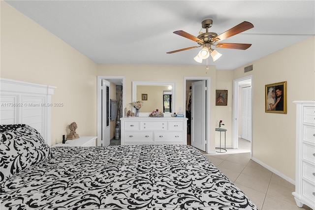 bedroom with ensuite bathroom, ceiling fan, and light tile patterned flooring