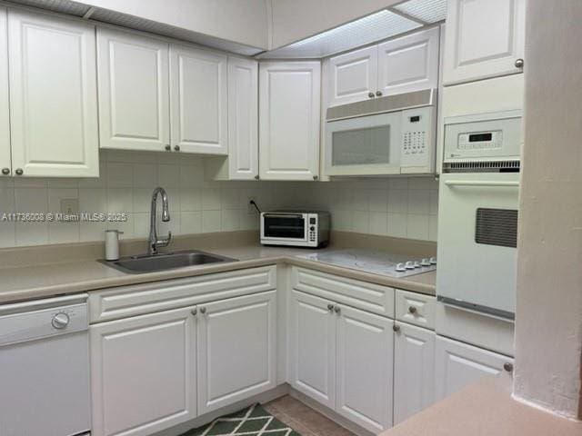 kitchen featuring sink, white cabinets, white appliances, and decorative backsplash