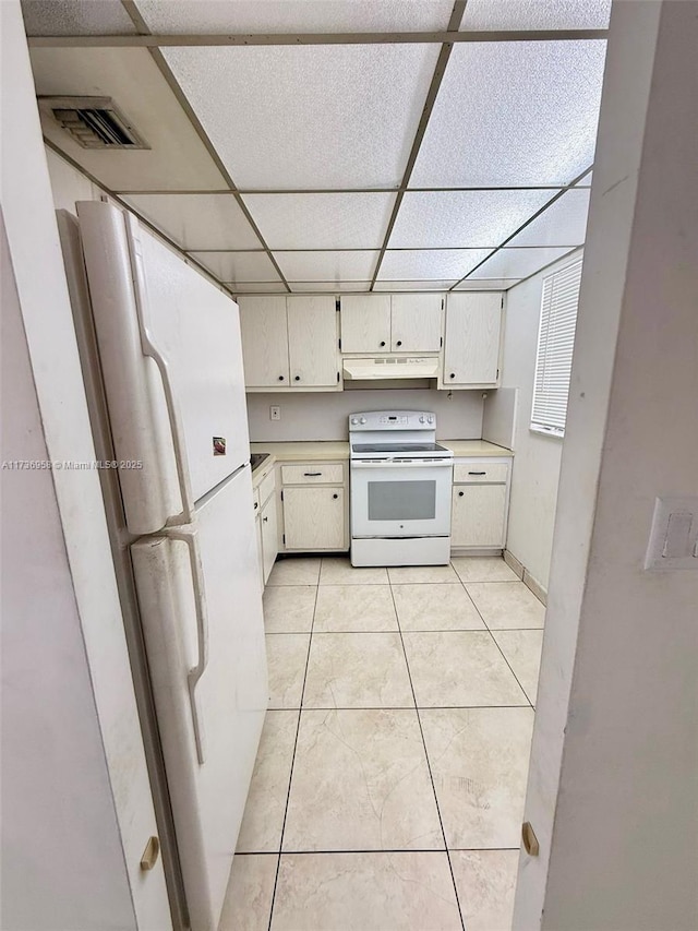 kitchen featuring light tile patterned floors, light countertops, visible vents, white appliances, and a drop ceiling