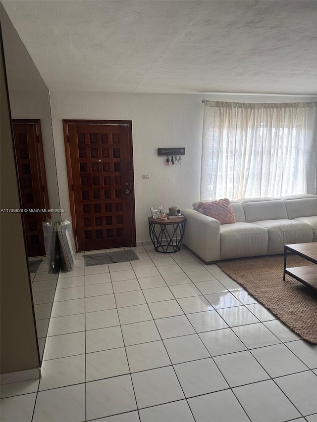 unfurnished living room with a textured ceiling and light tile patterned flooring