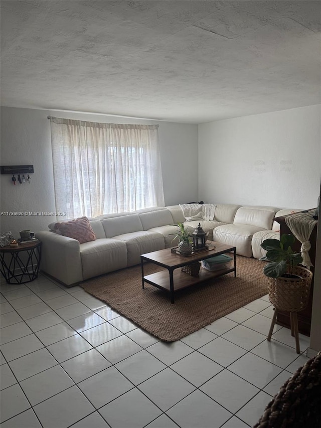 tiled living room featuring a textured ceiling