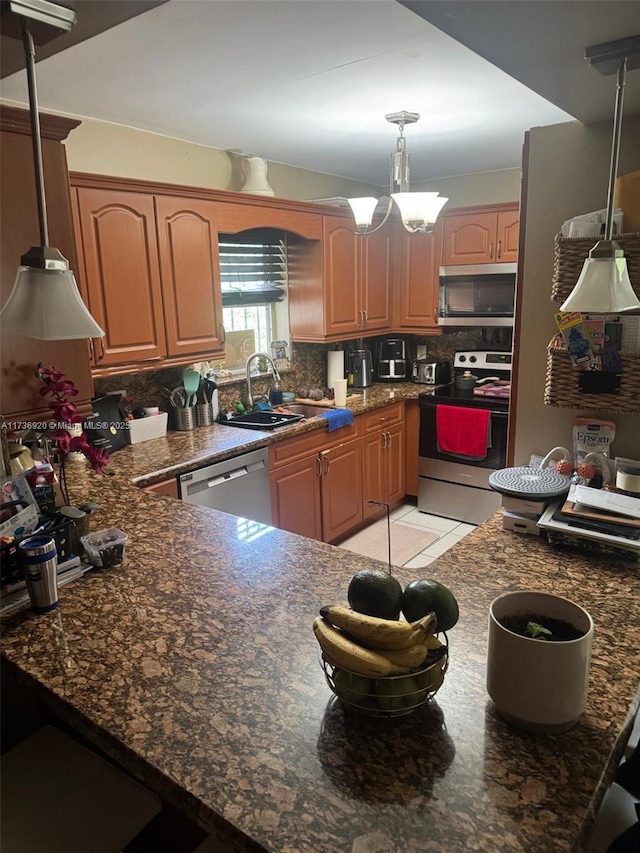 kitchen featuring decorative light fixtures, tasteful backsplash, sink, light tile patterned floors, and stainless steel appliances