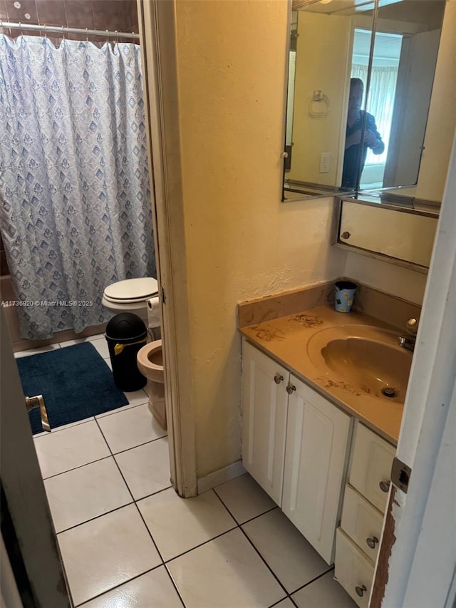 bathroom with a bidet, vanity, tile patterned floors, and toilet