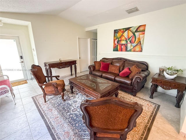 living room featuring light tile patterned flooring, vaulted ceiling, and a textured ceiling