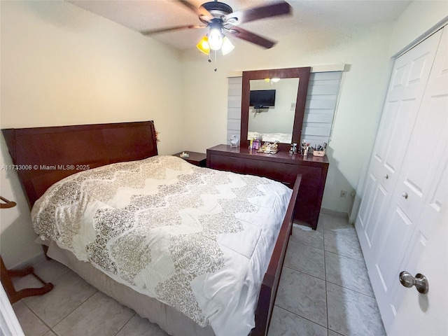 bedroom with ceiling fan, a closet, and light tile patterned floors