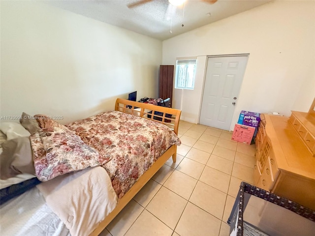 bedroom featuring vaulted ceiling, light tile patterned floors, and ceiling fan