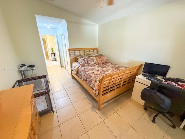 tiled bedroom with lofted ceiling and a textured ceiling