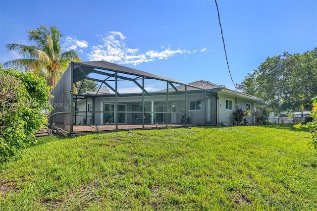 back of house with glass enclosure and a lawn