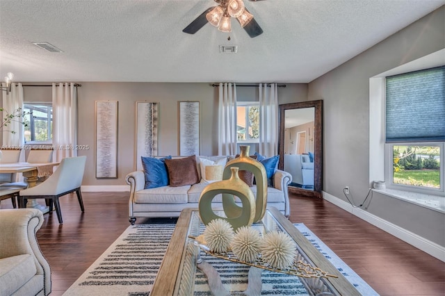 living room with ceiling fan, dark hardwood / wood-style flooring, and a textured ceiling