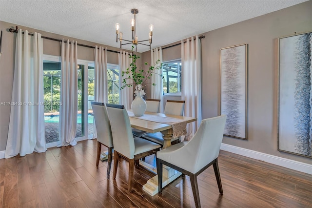 dining area featuring dark hardwood / wood-style floors, an inviting chandelier, and a textured ceiling