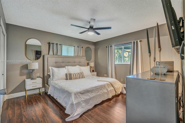 bedroom featuring ceiling fan, dark wood-type flooring, and a textured ceiling