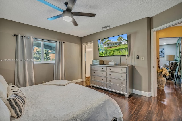 bedroom with ceiling fan, dark hardwood / wood-style floors, and a textured ceiling