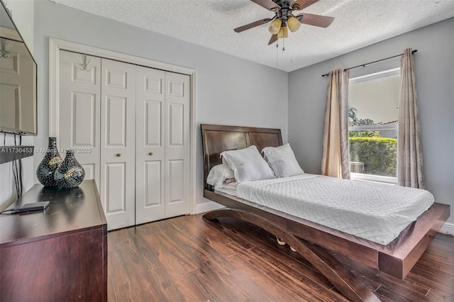 bedroom with a closet, dark hardwood / wood-style floors, a textured ceiling, and ceiling fan