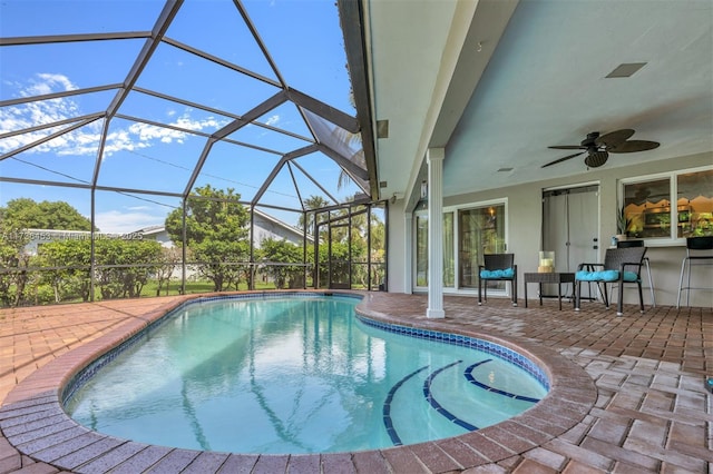 view of pool with ceiling fan, a lanai, and a patio